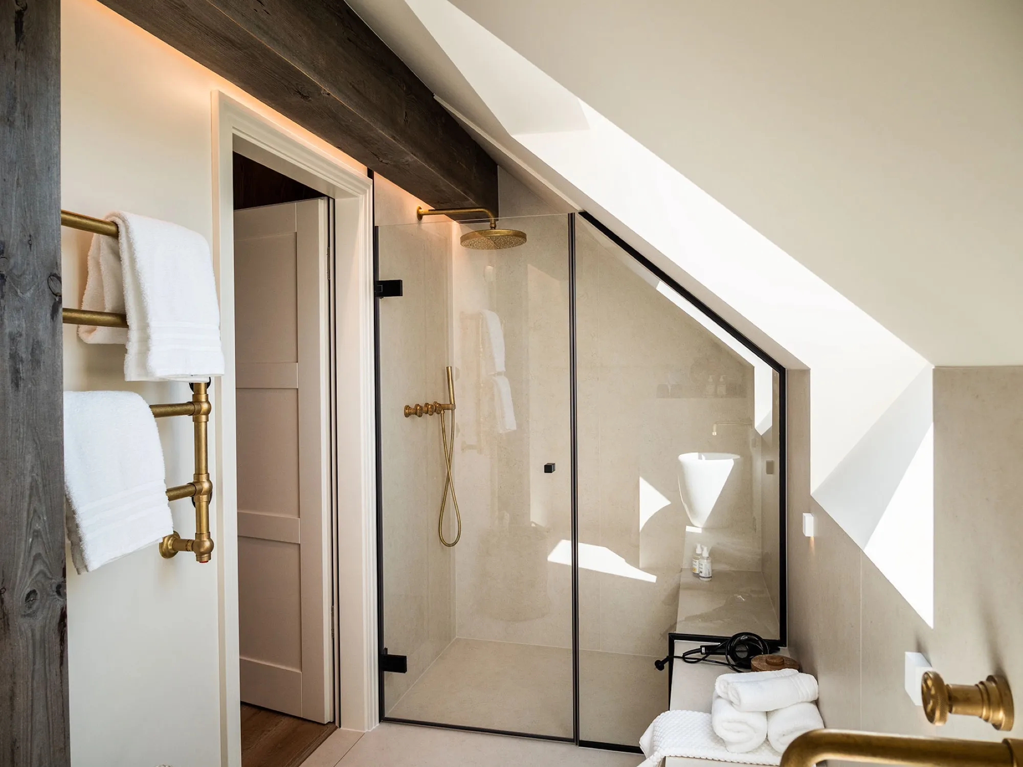Regendusche unter der Dachschräge, Messingarmaturen, viel Licht durch das Dachfenster